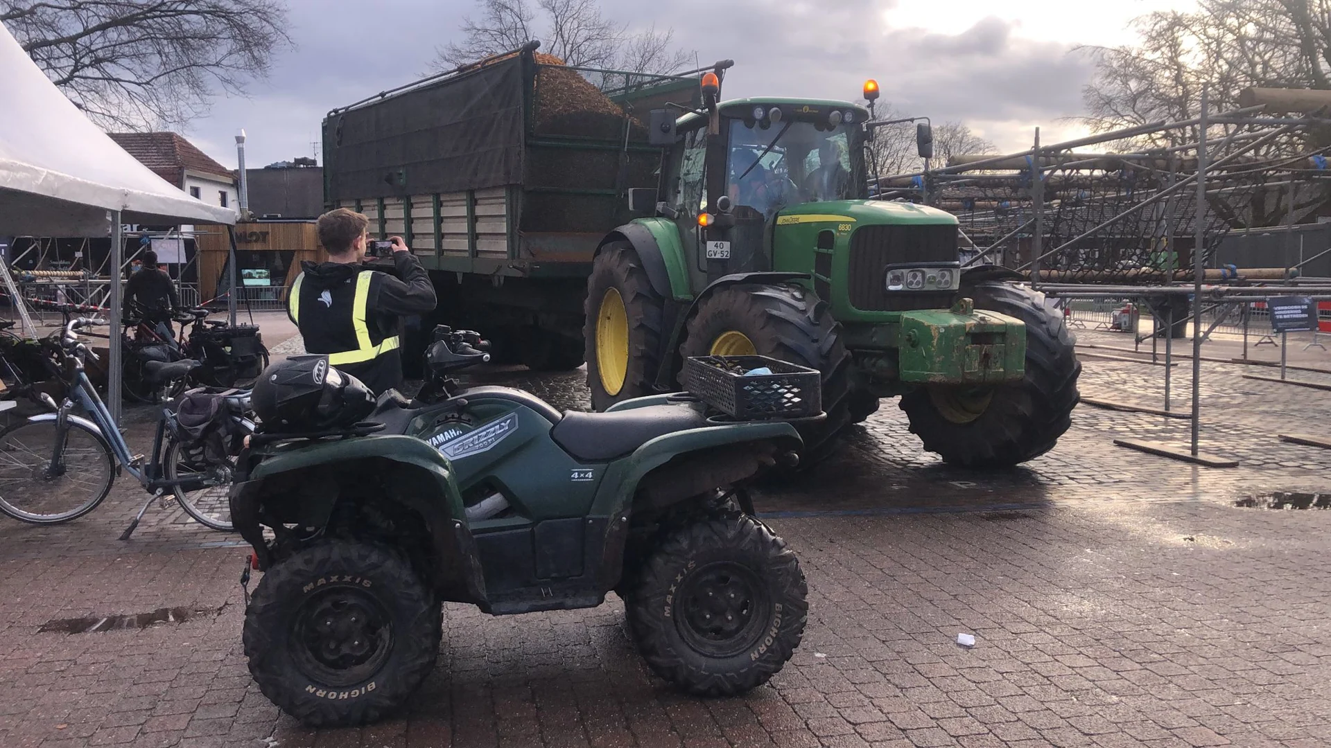 Een tractor met een aanhanger vol houtsnippers rijdt het Raadhuisplein op.