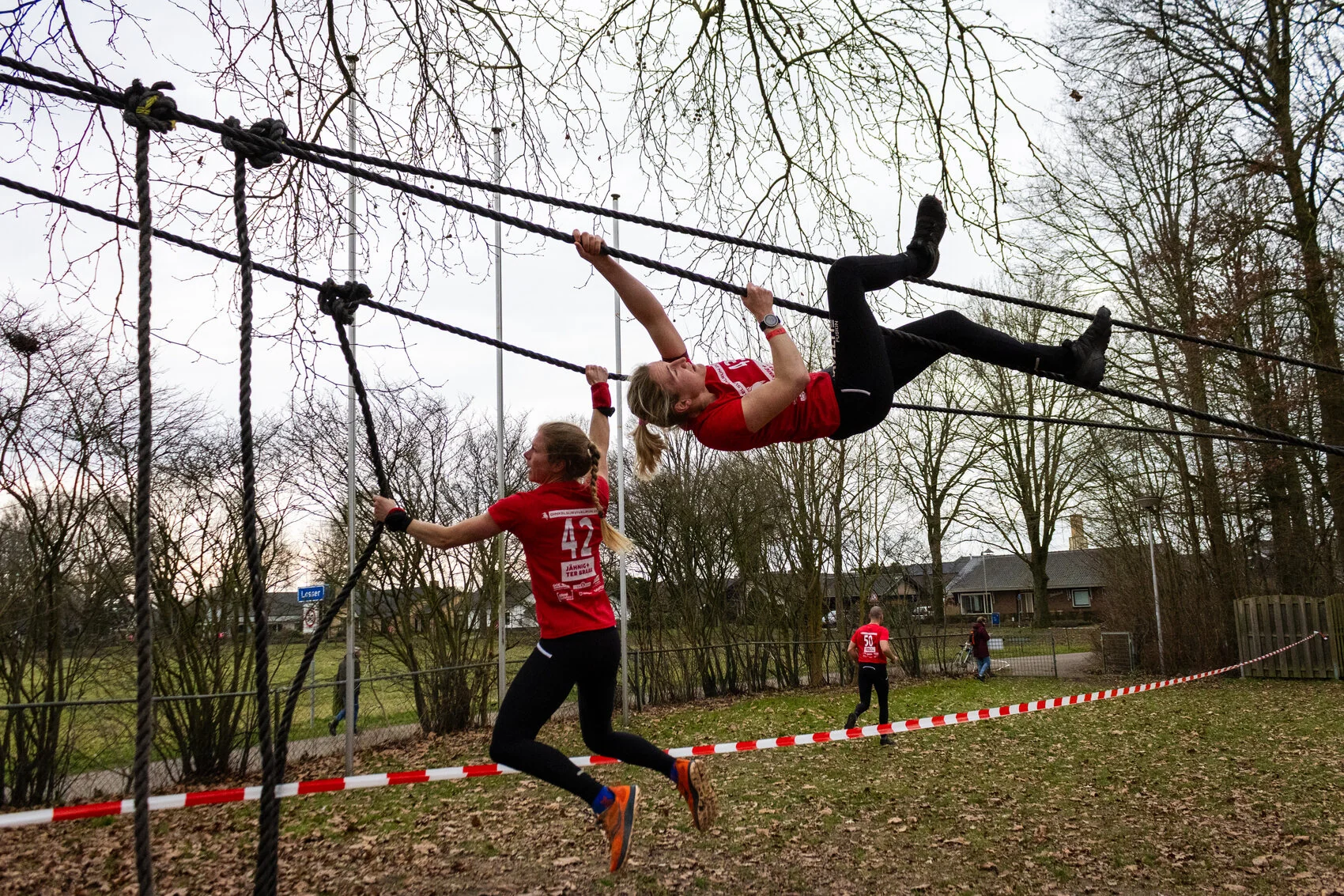 Deelnemers overwinnen een touwhindernis tijdens de Dinkel Survivalrun.
